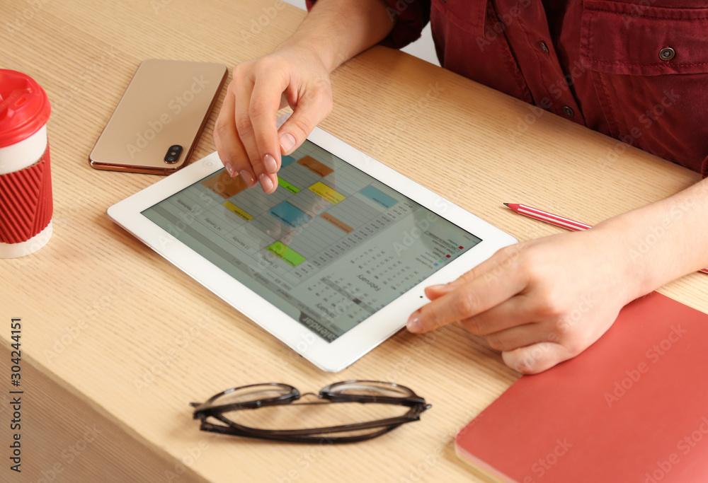 Wall mural Woman using calendar app on tablet in office, closeup