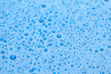 Water drops on blue background, closeup view