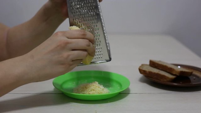 Hands grating cheese. Close-up footage.