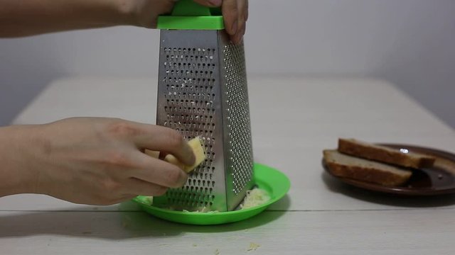 Hands grating cheese. Close-up footage.