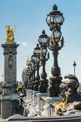 Fototapeta na wymiar Pont Alexandre III details with the Eiffel Tower in the background, with blue sky