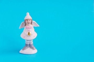 Christmas figurine of a cute angel with a golden heart on a blue background. Congratulations to the...
