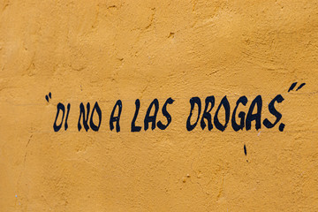 Di no a las drogas pintado en pared amarilla desgastada . 