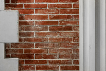Fragment of a white column on a background of a red brick wal