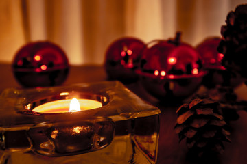 Christmas candles, red apples, cones and spices on rustic wooden background with  Balls and Christmas lights. Close up, selective focus 