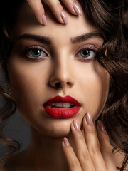 Face of a beautiful woman with a smoky eye makeup and red lipstick