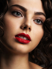 Face of a beautiful woman with a smoky eye makeup and red lipstick