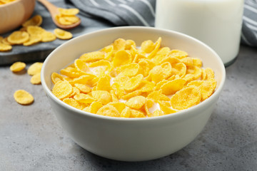 Tasty corn flakes with milk on light grey table, closeup