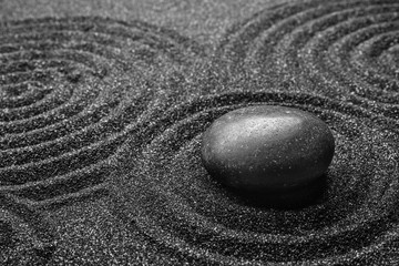 Fototapeta na wymiar Black sand with stone and beautiful pattern. Zen concept