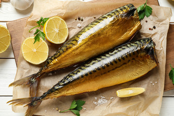 Flat lay composition with tasty smoked fish on white wooden table