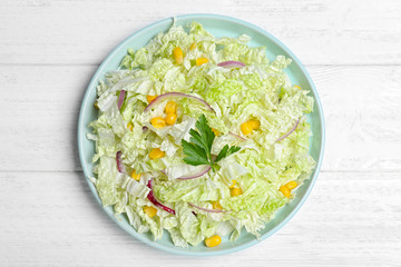 Fresh napa cabbage salad served on white wooden table, top view
