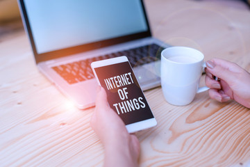 Writing note showing Internet Of Things. Business concept for connection of Devices to the Net to Send Receive Data woman with laptop smartphone and office supplies technology