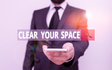 Word writing text Clear Your Space. Business photo showcasing Clean office studio area Make it empty Refresh Reorganize Male human wear formal work suit hold smart hi tech smartphone use one hand