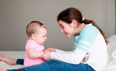 Close up Portrait of Two Sisters, Cute 8 Month Old baby Girl with Big blue Eyes and 8 Years Old School Age Girl With Brown Eyes , Happy Baby Girl