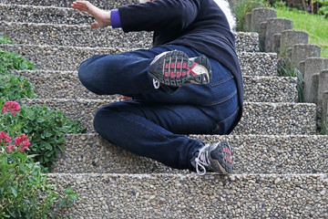 Eine ältere Frau ist auf einer Treppe ausgerutscht und hingefallen