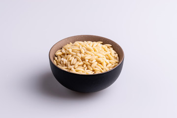 Orzo pasta, isolated on white background. Italian orzo pasta shaped like grains of rice, copy space, soft light