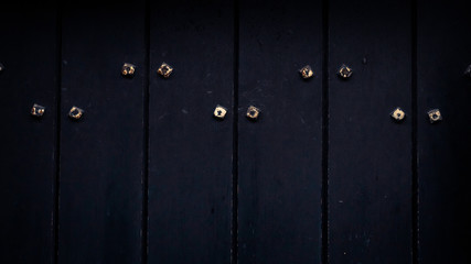 Obraz premium black wooden door with metal studs