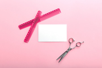 Hairdresser. Scissors, combs, other hairdresser accessories and strand of blonde hair on pink background. Mockup for gift card. Flat lay with space for text. Hairdresser service. Beauty salon service