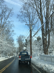 Old truck driving on small town road in winter
