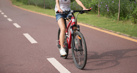 Naklejka premium Woman riding bike in park