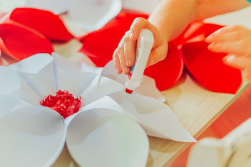  lady's hand sticking glue on paper a large flower-shaped origami for decoration