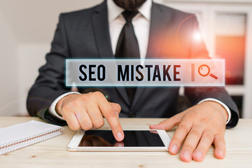 Obraz premium Conceptual hand writing showing Seo Mistake. Concept meaning action or judgment that is misguided or wrong in search engine Male human wear formal clothes present use hitech smartphone