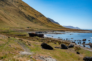 Abandoned rusty ship wreck beached on the coast above the beach at White rock Cape Palliser