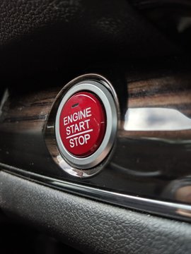 Selective focus on a bright red push start button for keyless car ignition