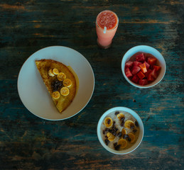 Tasty Pancakes with sweet honey and banana on a clay plate