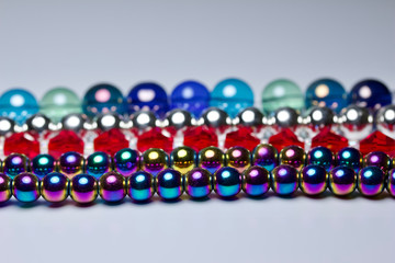 Macro abstract texture border of colorful strands of beads on white background with copy space