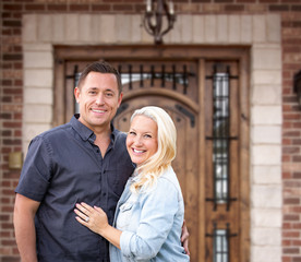 Happy Young Couple In Front of Front Door of New House