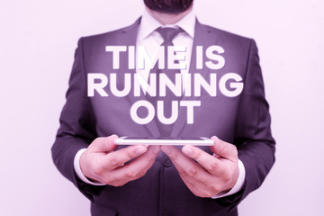 Text sign showing Time Is Running Out. Business photo text Deadline is approaching Urgency things cannot wait Male human wear formal work suit hold smart hi tech smartphone use hands
