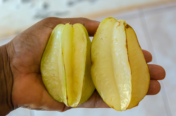 Two Starfruit In The Palm Of A Hand