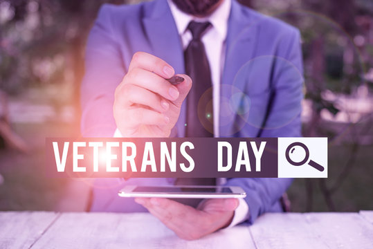 Handwriting text Veterans Day. Conceptual photo a public holiday to honour US veterans and victims of all wars Businessman pointing with pen in empty copy space