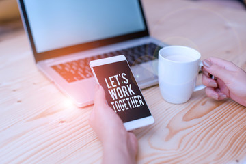 Writing note showing Let S Work Together. Business concept for Unite and Join Forces to Achieve a Common Goal woman with laptop smartphone and office supplies technology