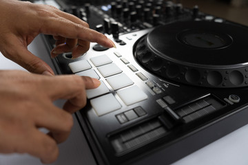 Hands of DJ mixing tracks on professional sound mixer.Fashionable rings on fingers of girl disc...