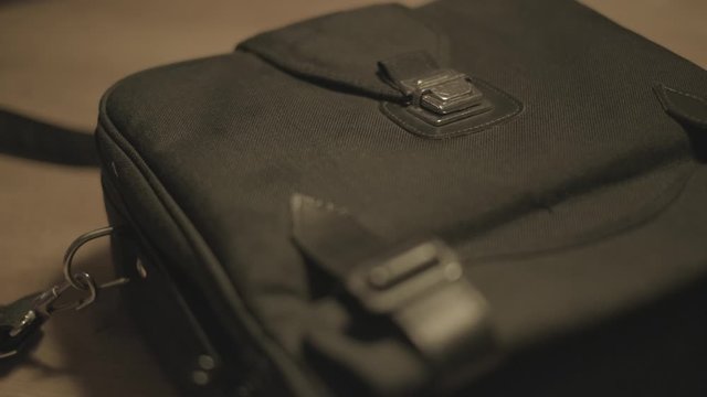 4k shot putting a retro camera bag in a table
