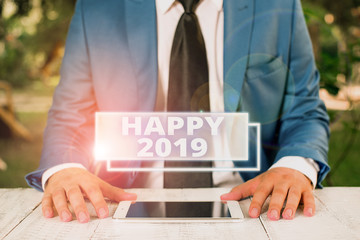 Writing note showing Happy 2019. Business concept for feeling showing or causing pleasure or satisfaction for 2019 Businessman in blue suite with a tie holds lap top in hands