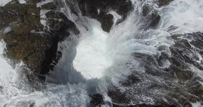 Up close aerial perspective shot of Thors Well as it drinks in the teal ocean water; this natural wonder is an amazing sinkhole located in the PNW region of the United States off the coast of Oregon  