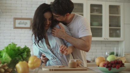 Lovely couple flirting at home. Sensual woman flirting with man at kitchen - Powered by Adobe