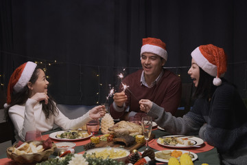 happy family party and play sparkle fire to celebrate on christmas dinner in dining room that decorated with christmas tree for christmas festival day, happy family holiday concept