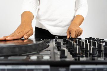 Hands of DJ mixing tracks on professional sound mixer.Fashionable rings on fingers of girl disc...