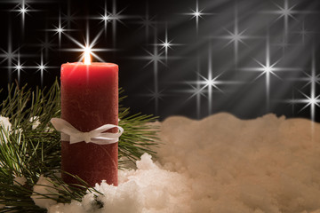 lit white candle and red ribbon with pine needles with beam of light in snow. Christmas Background...