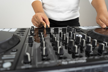 Hands of DJ mixing tracks on professional Dj Mixer