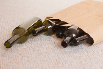 green and brown beer and wine empty glass liquor bottles in a paper bag