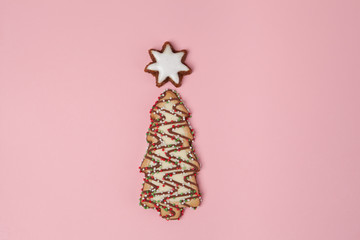 Christmas tree biscuit with almond star on pink background - top view with copy space