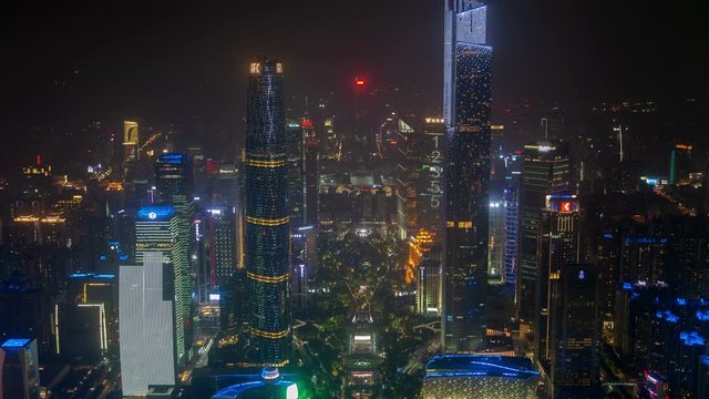 Timelapse modern flashing Guangzhou downtown highrise buildings and skyscrapers with colourful advertisement illumination in China at dark night