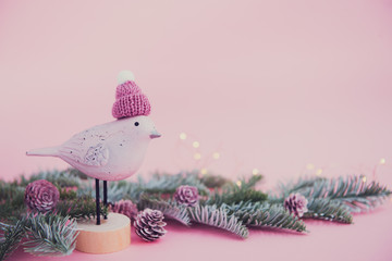 christmas decoration - wooden bird, fir tree and cones on pink background