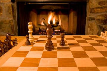 Chess Board and Pieces with Fireplace in Background