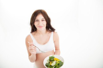Pregnant, eating a green leafy salad,